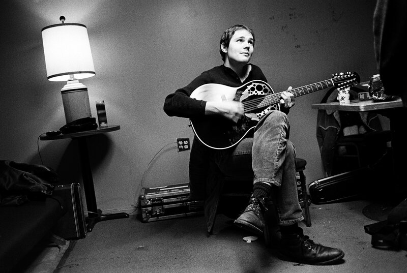 Musician playing guitar in a room