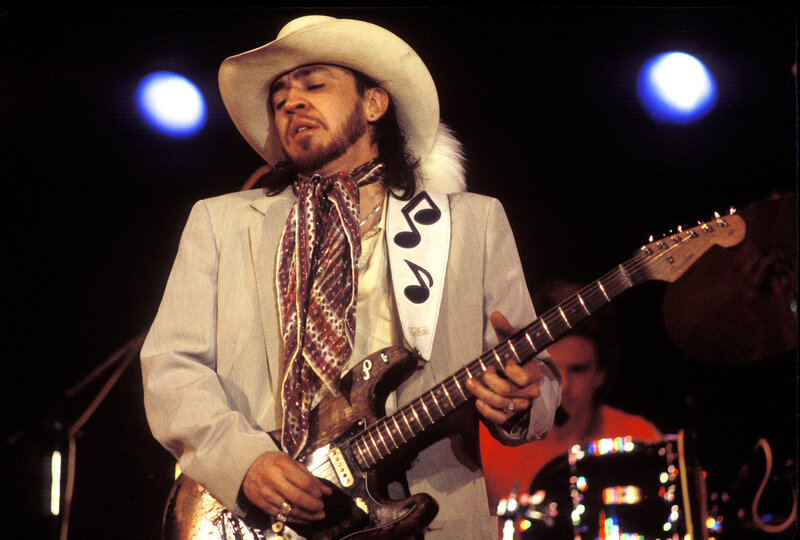 Musician playing guitar on stage