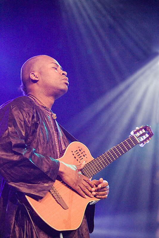 Musician playing guitar on stage
