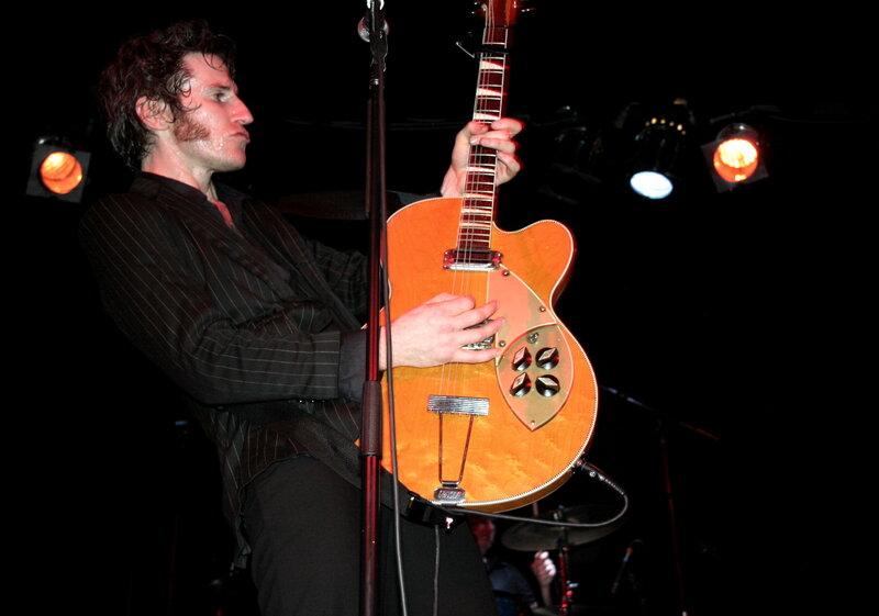 Musician playing guitar on stage