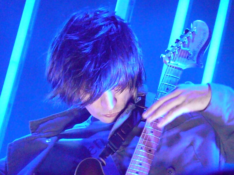 musician playing guitar on stage