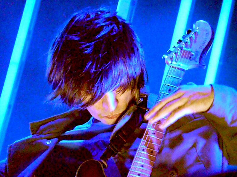 Musician playing guitar on stage