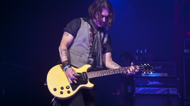 musician playing guitar on stage