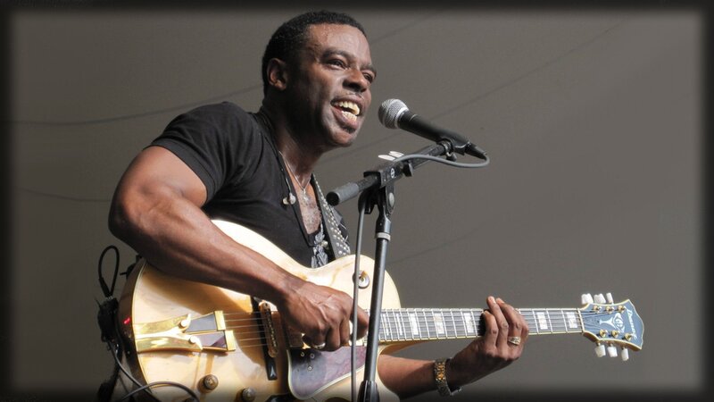 musician playing guitar on stage