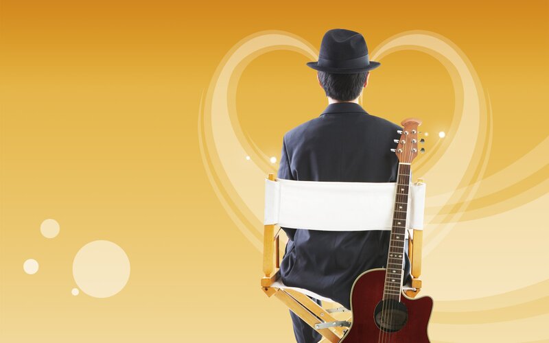 Musician with guitar in chair