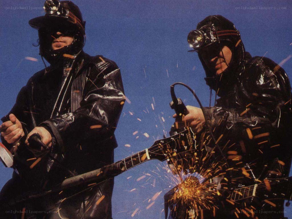 Musicians in mining gear with sparks