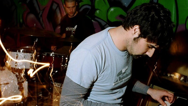 Musicians performing in a graffiti-filled room