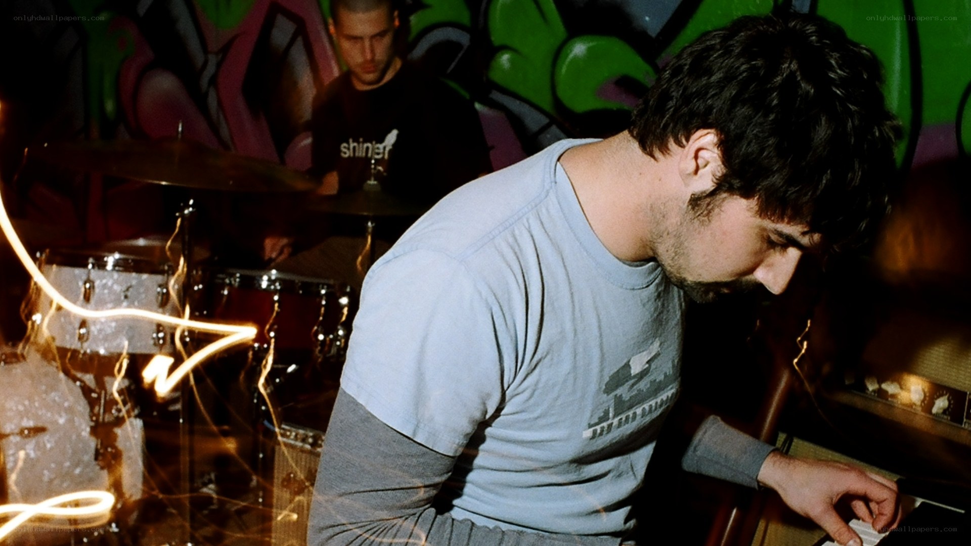 Musicians performing in a graffiti-filled room