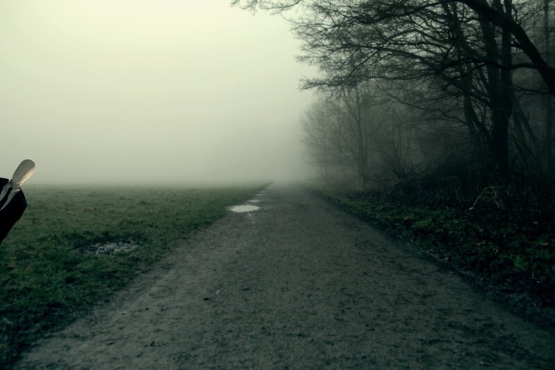 Mysterious figure on a foggy path