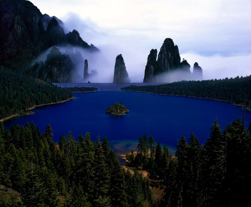 Mystical lake with forested mountains