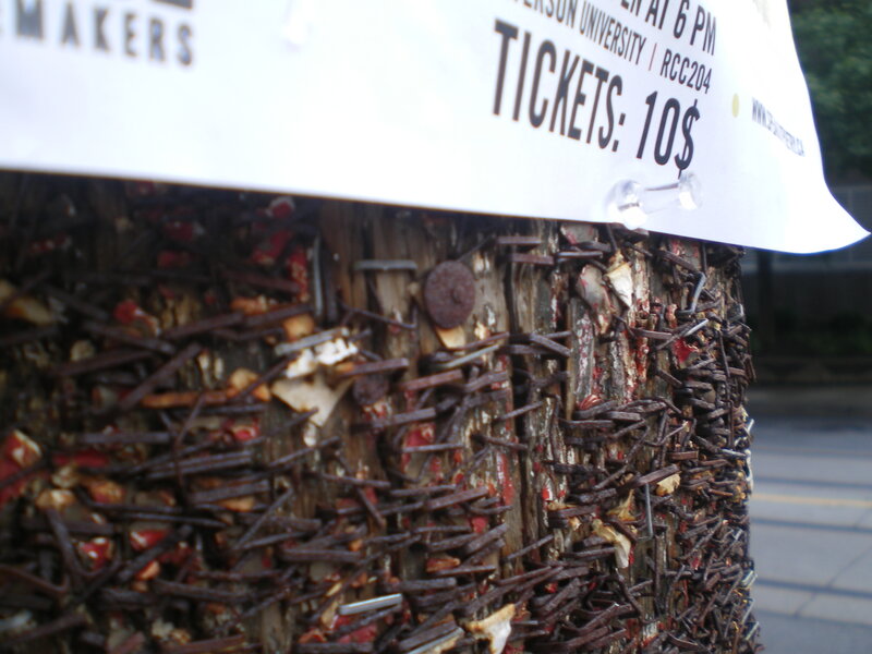 Nail-covered post with sign