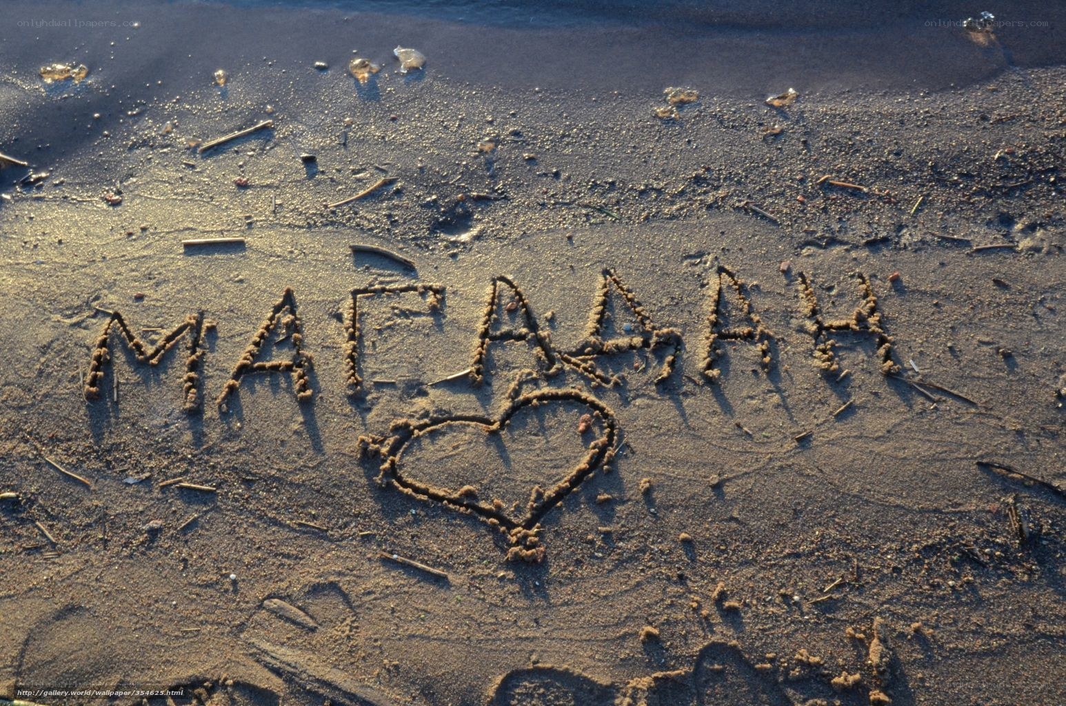 name and heart drawn in sand