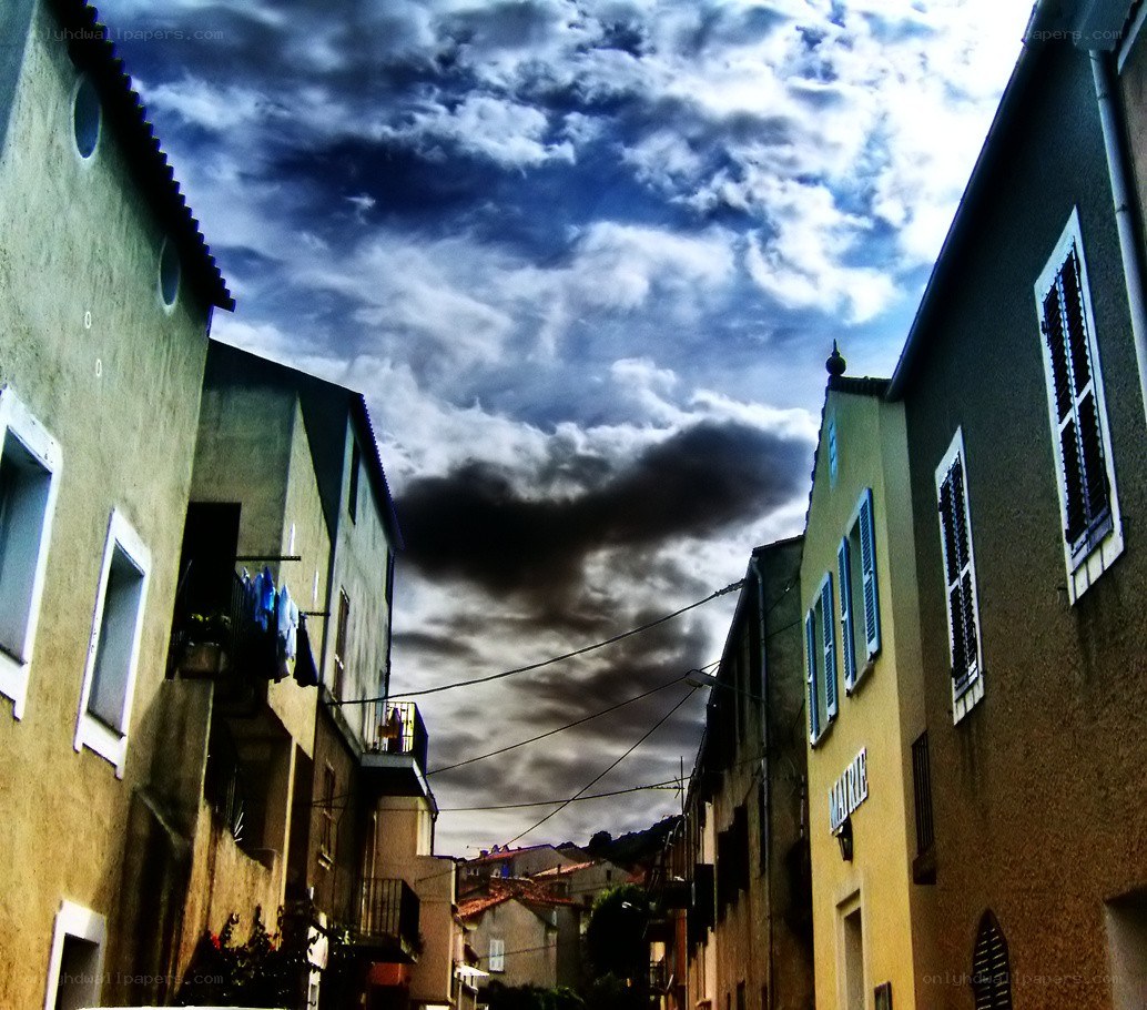 Narrow street with dramatic sky
