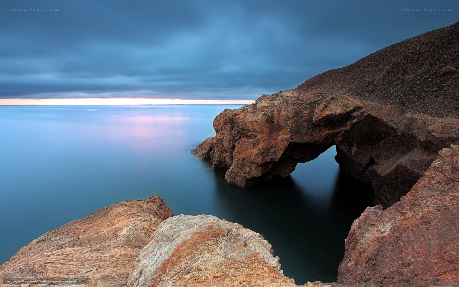 Natural rock arch at coastal sunset