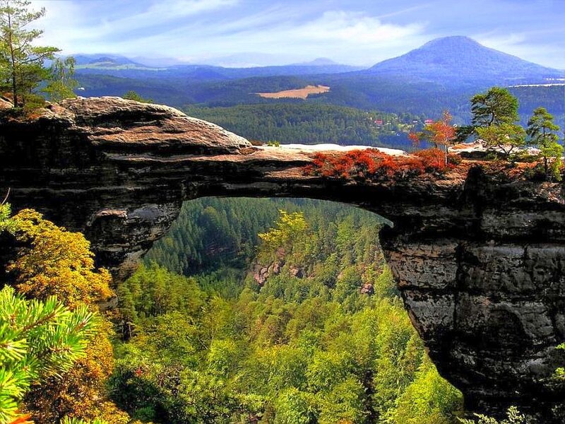Natural rock arch in forested valley