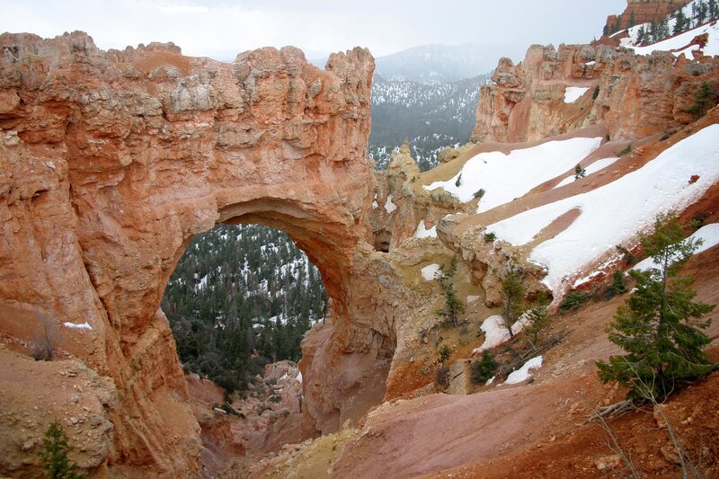 Natural rock arch in snowy canyon