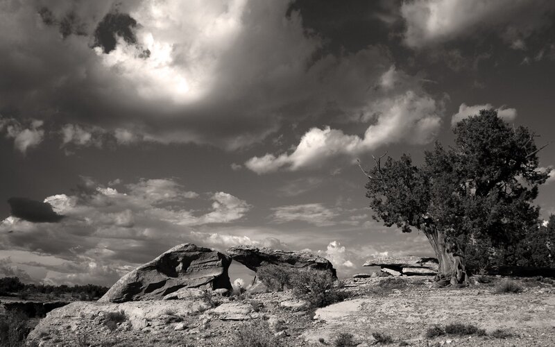 Natural rock arch under cloudy sky