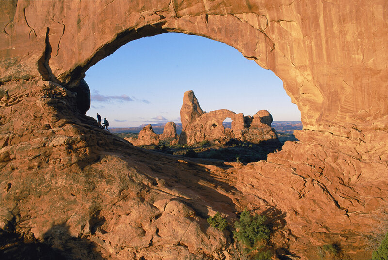 Natural rock arch with hikers