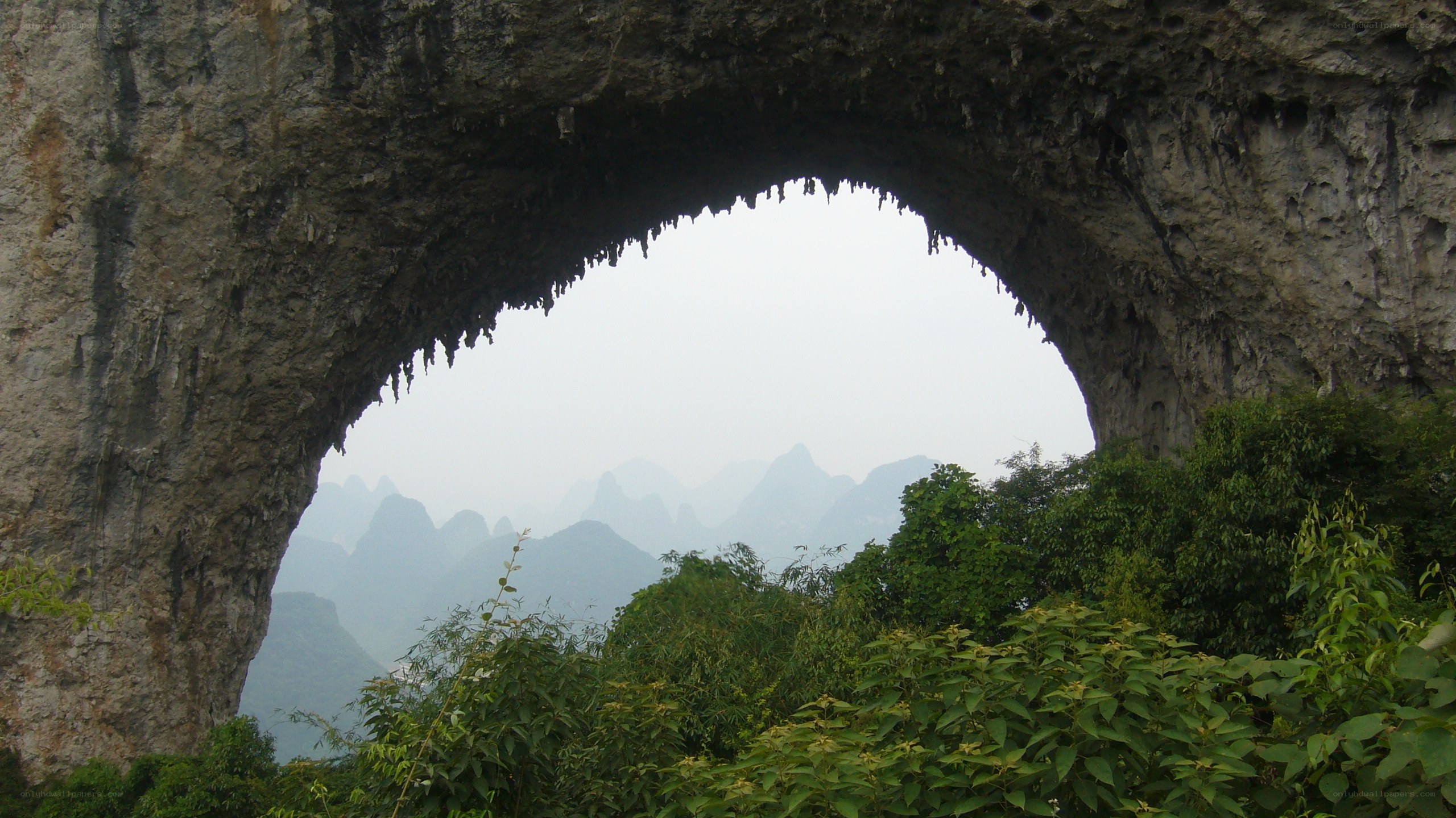 Natural rock arch with karst mountains