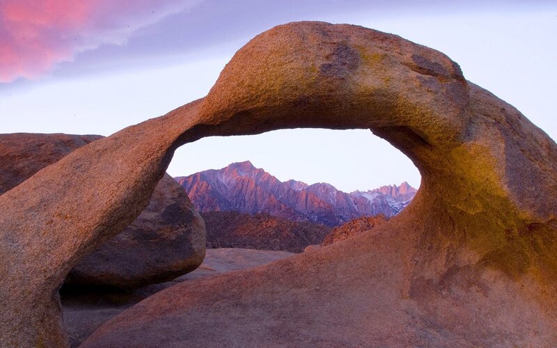 Natural rock arch with mountain view