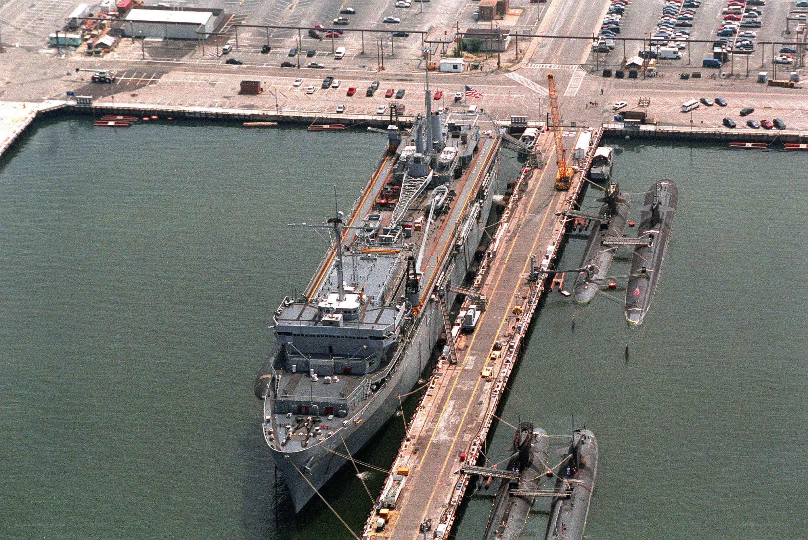 Naval ship at dock with submarines