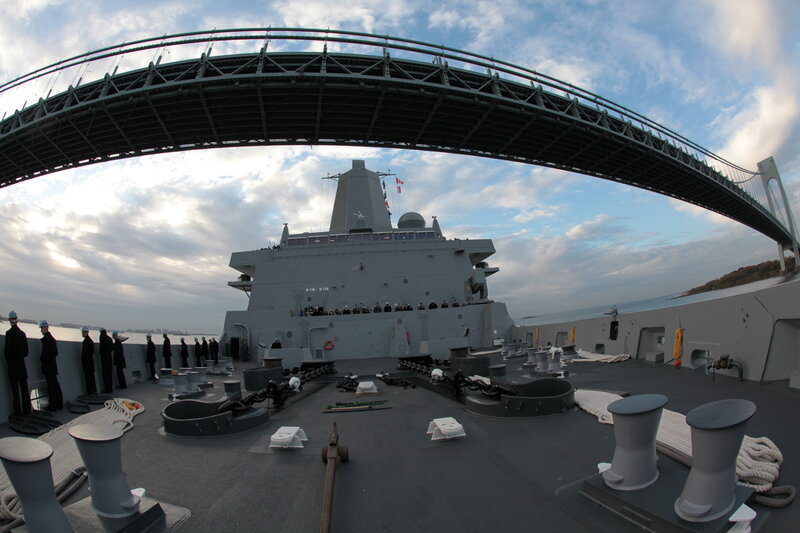 Naval ship passing under a bridge