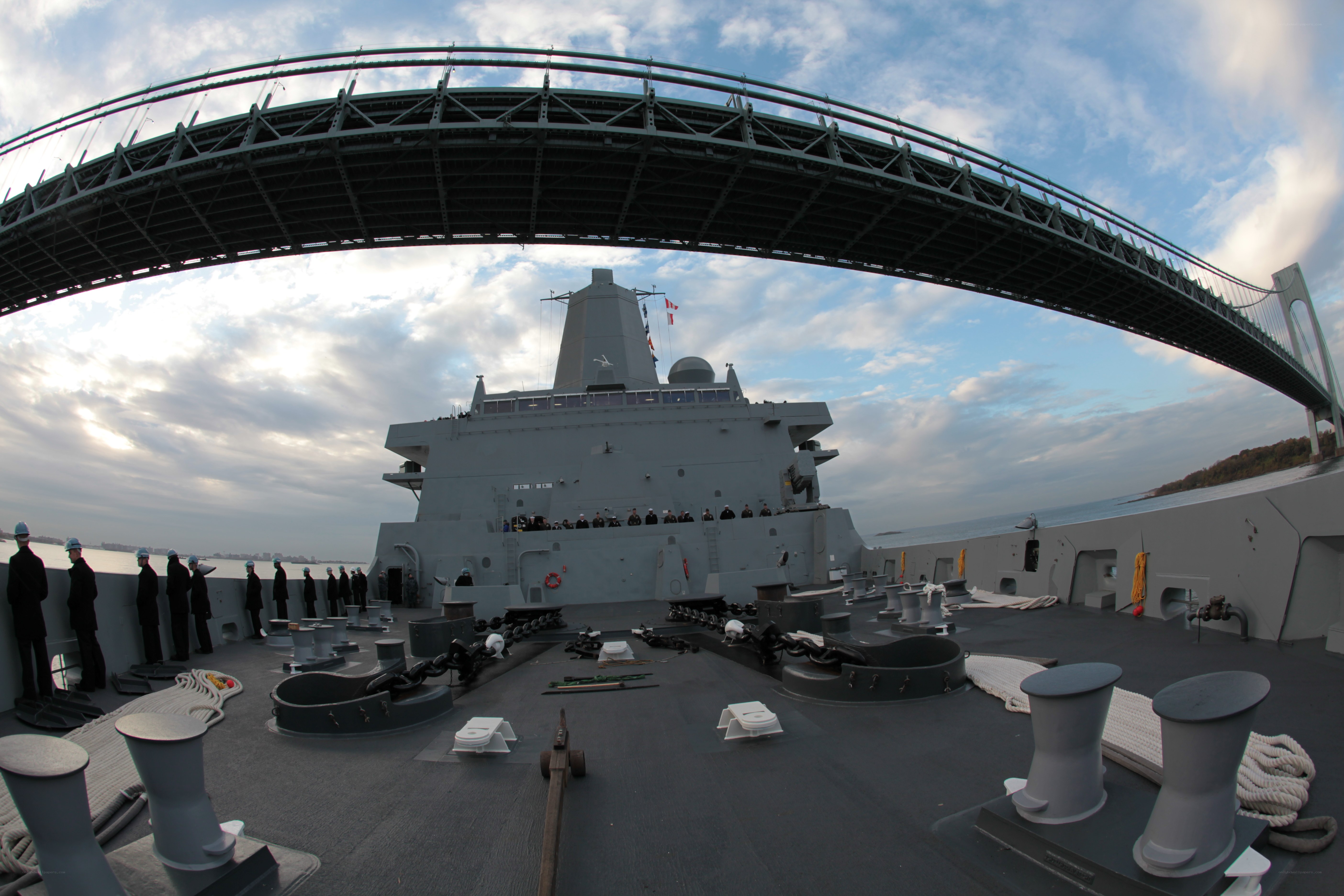 Naval ship passing under a bridge