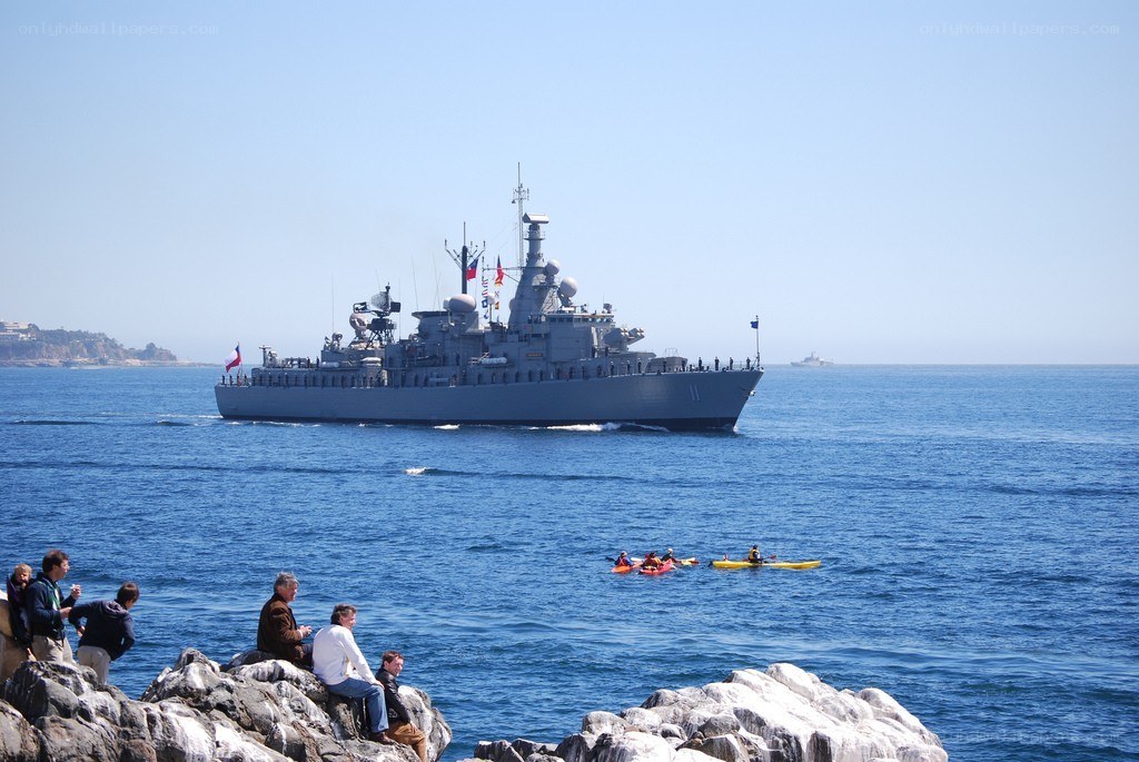 Naval ship sailing near coast