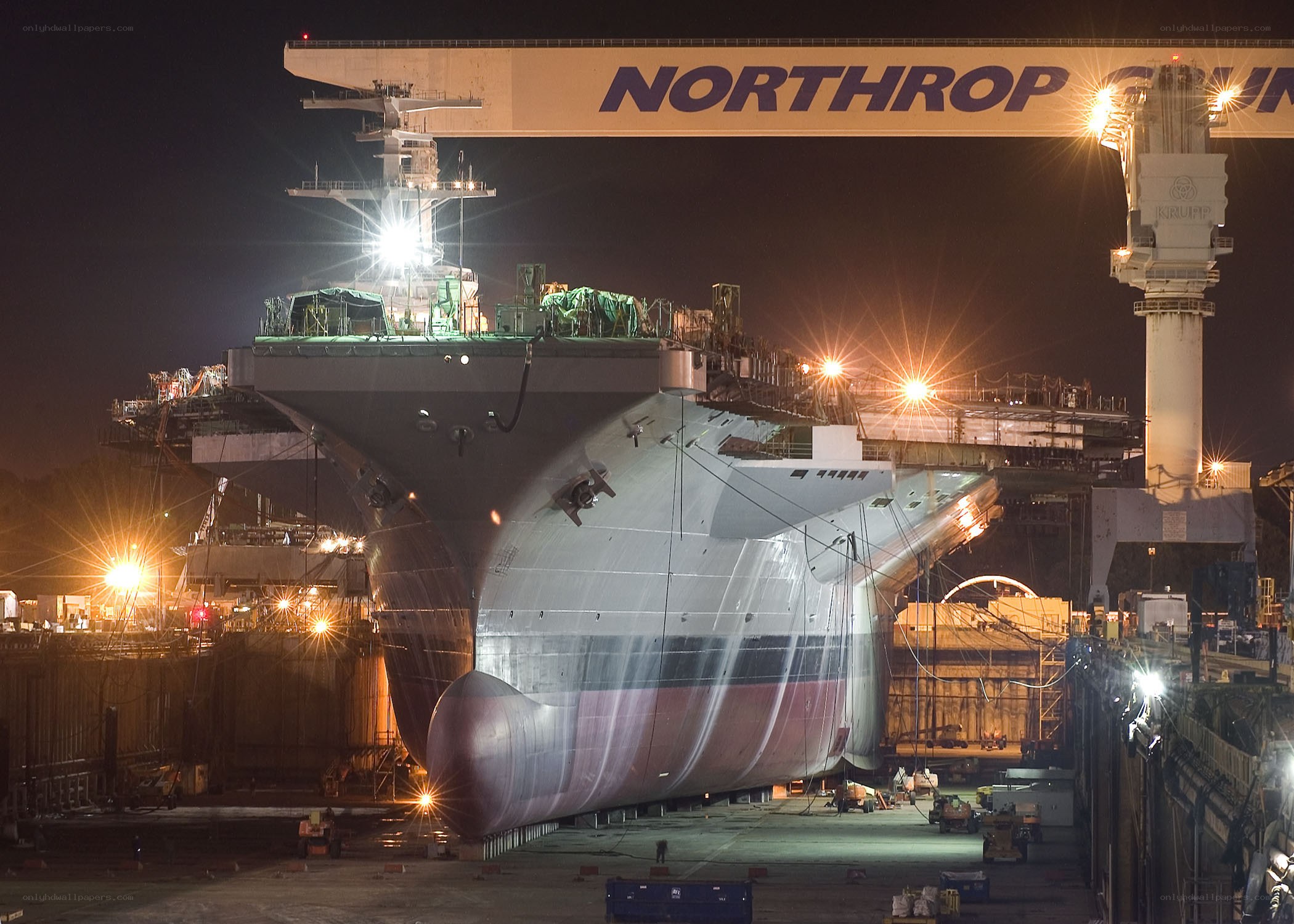 Naval ship under construction at night