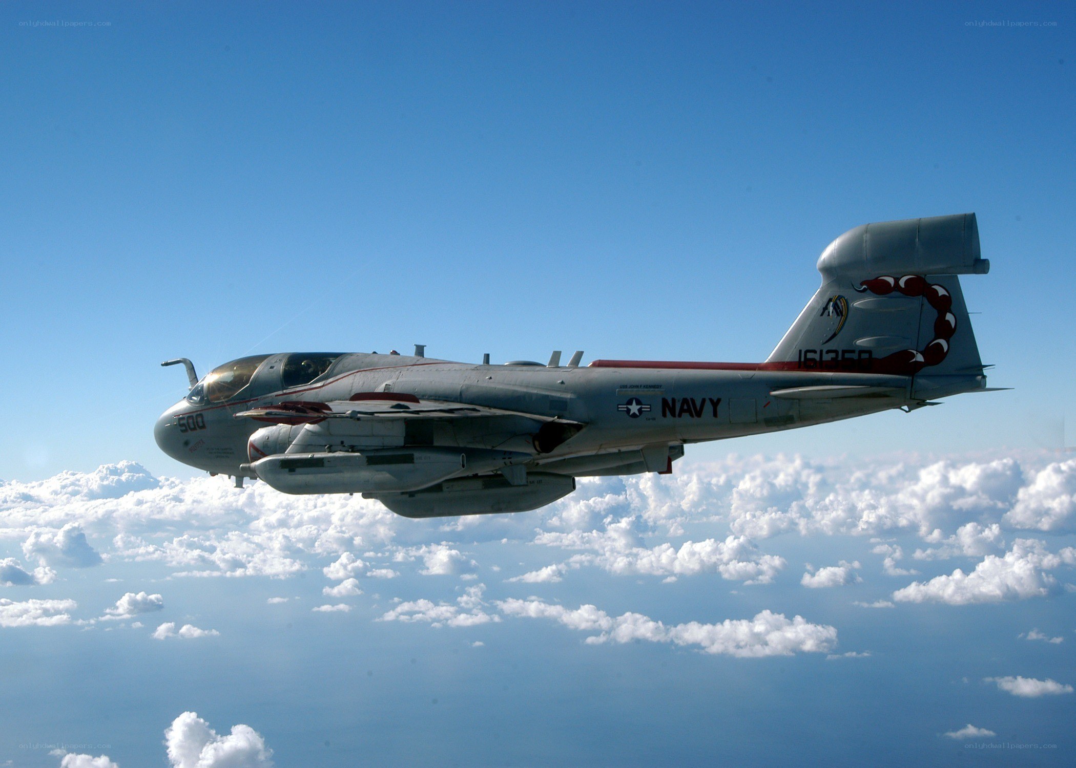 Navy aircraft flying above clouds