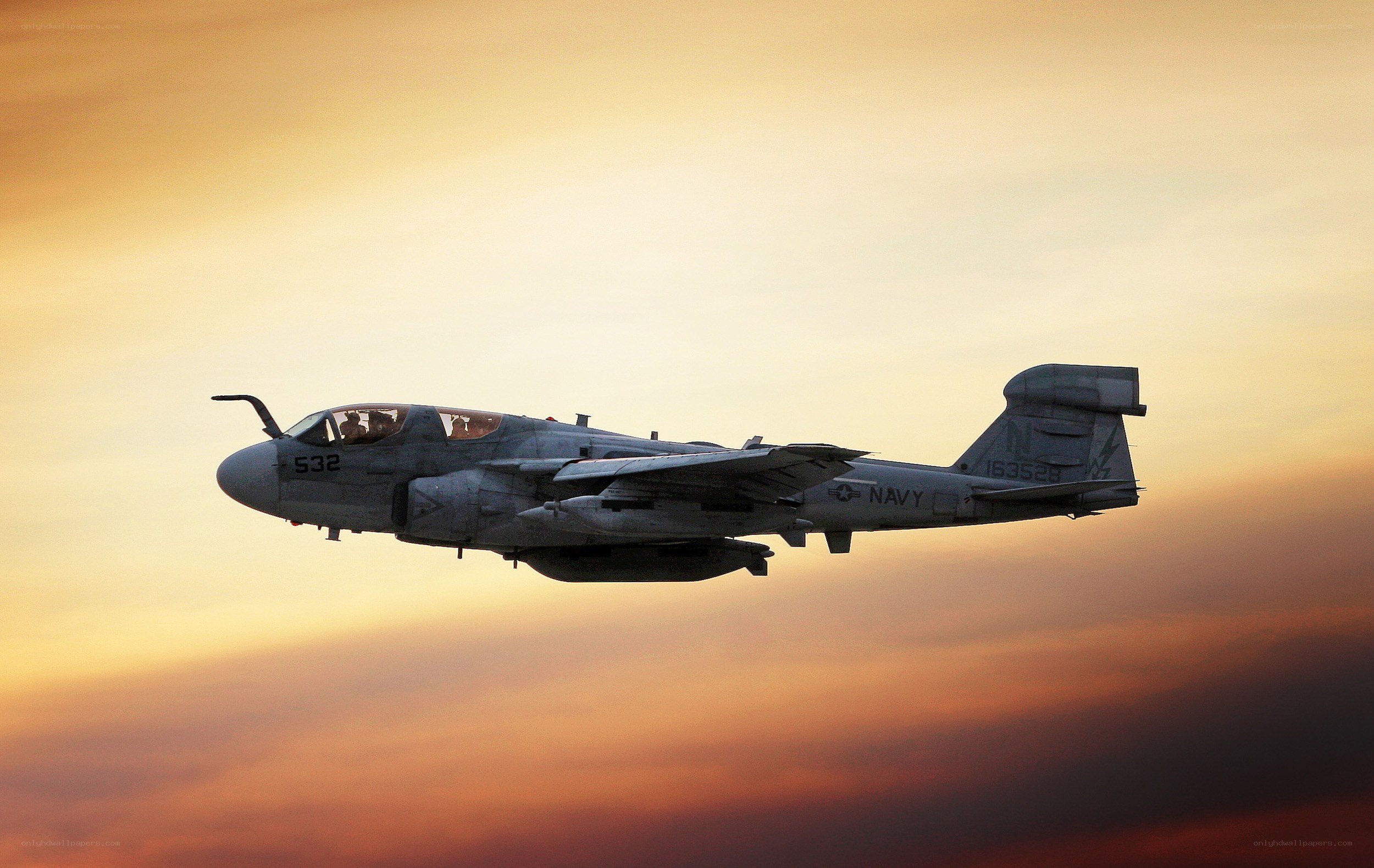 Navy aircraft in flight at sunset
