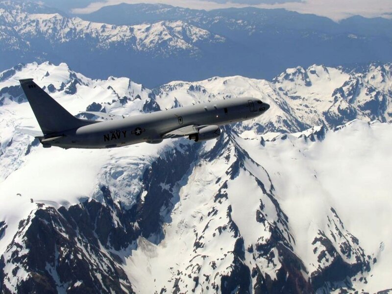 Navy aircraft over snowy mountains