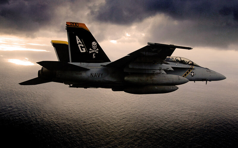 Navy fighter jet over ocean