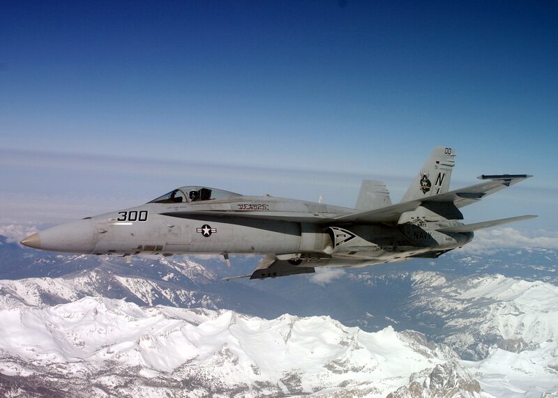 Navy fighter jet over snowy mountains