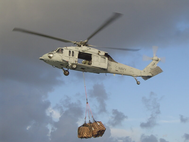 Navy helicopter lifting cargo