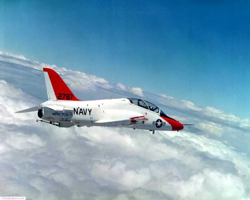Navy jet flying above clouds