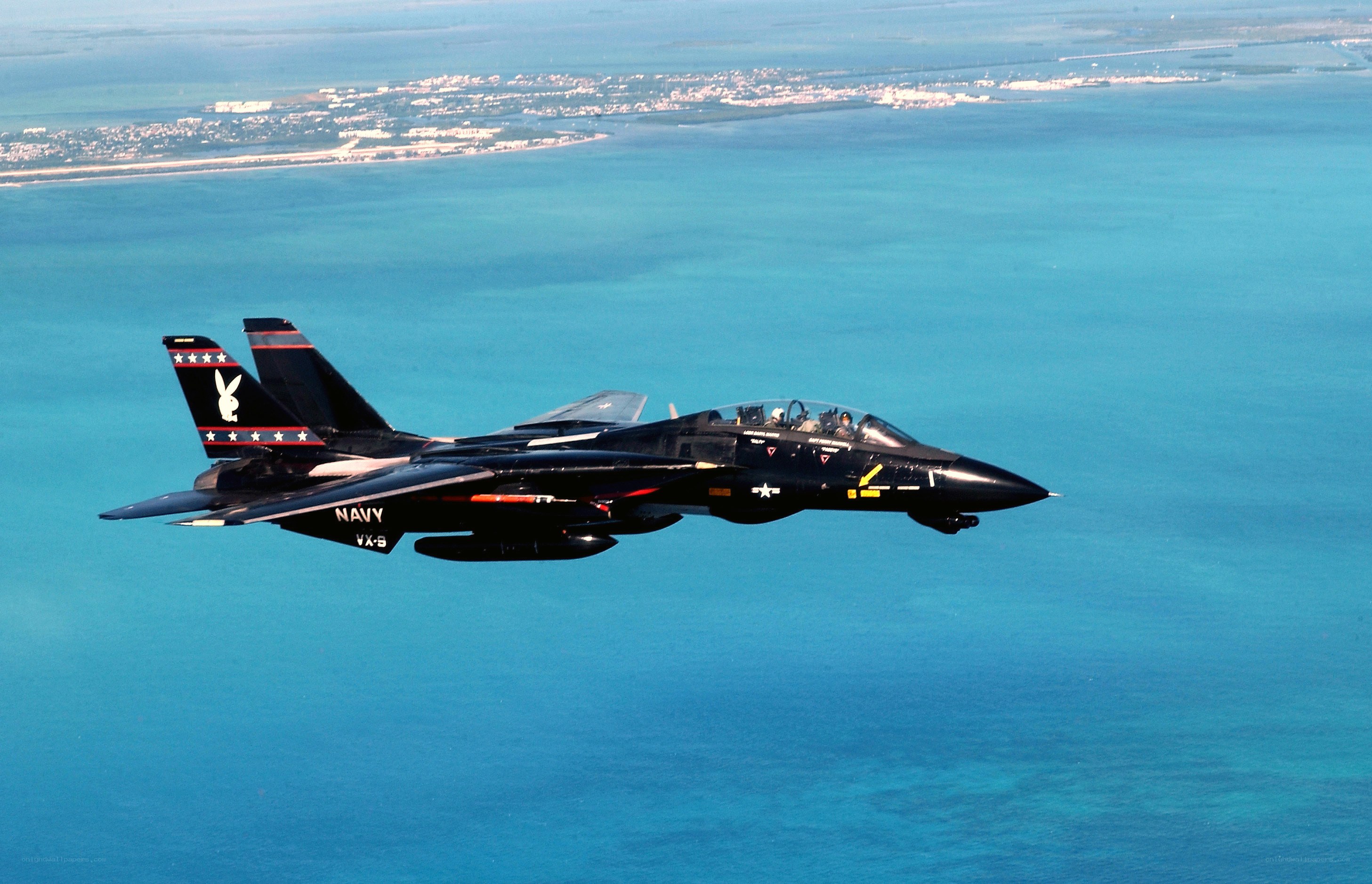 Navy jet flying over ocean