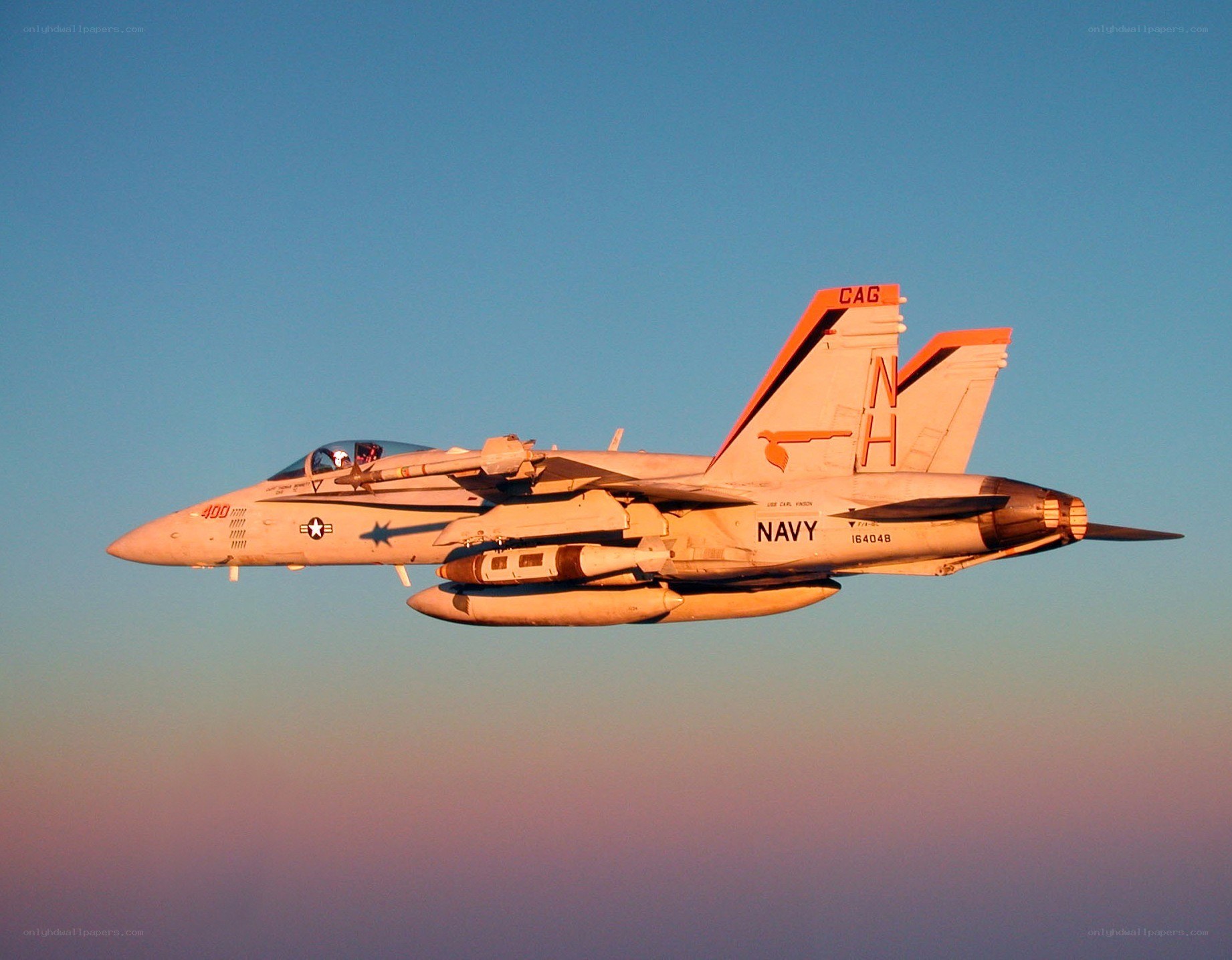 Navy jet in flight at sunset