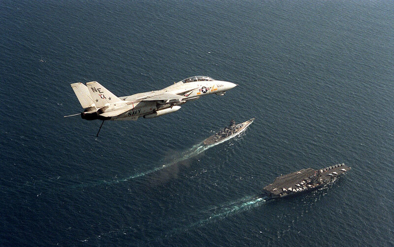 Navy jet over aircraft carriers