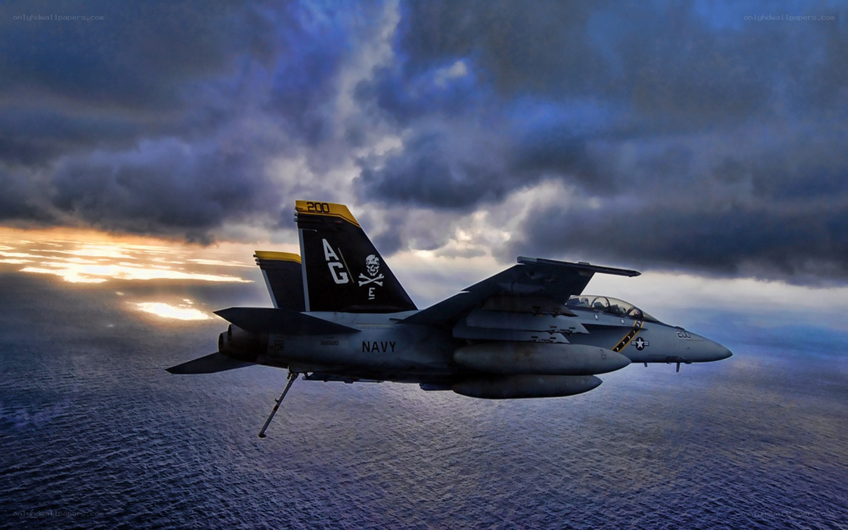 Navy jet over ocean at sunset