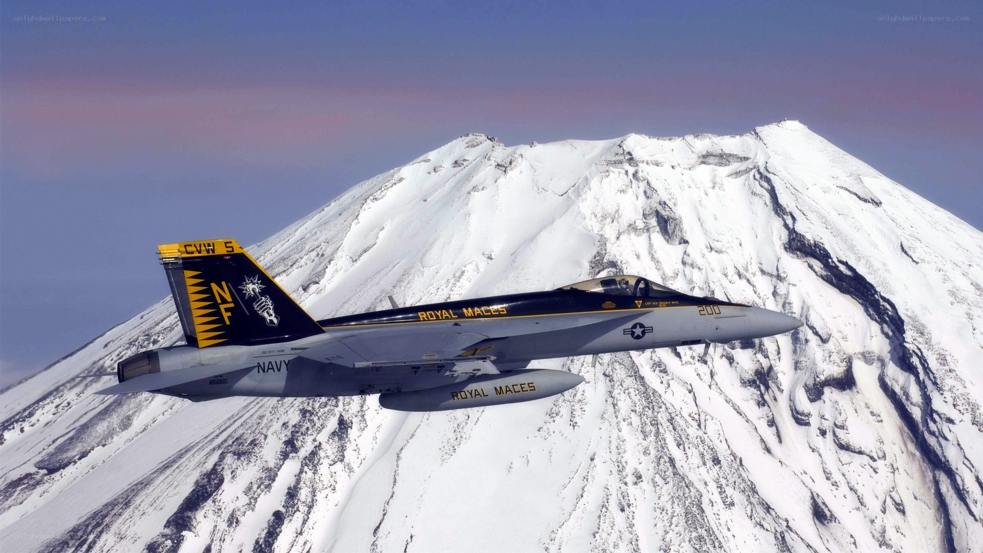 Navy jet over snowy mountain