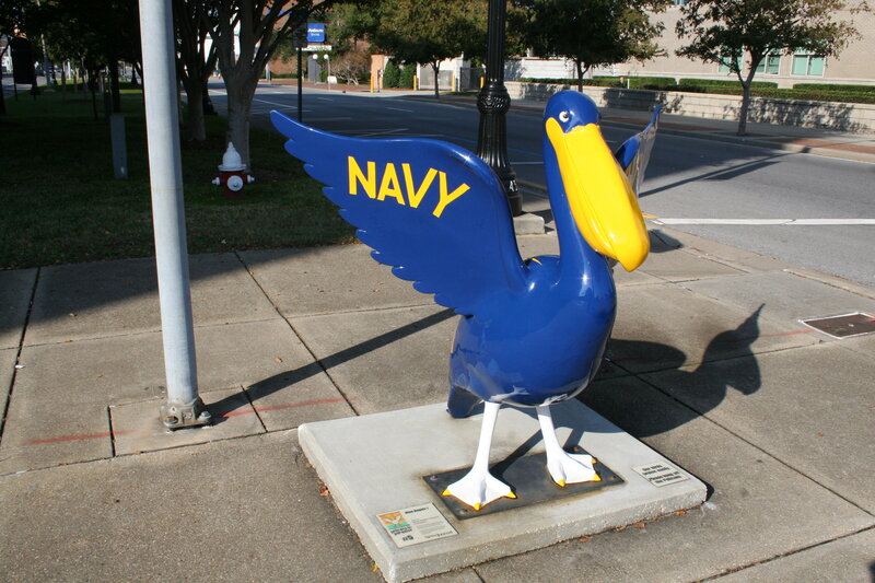 Navy pelican statue on sidewalk