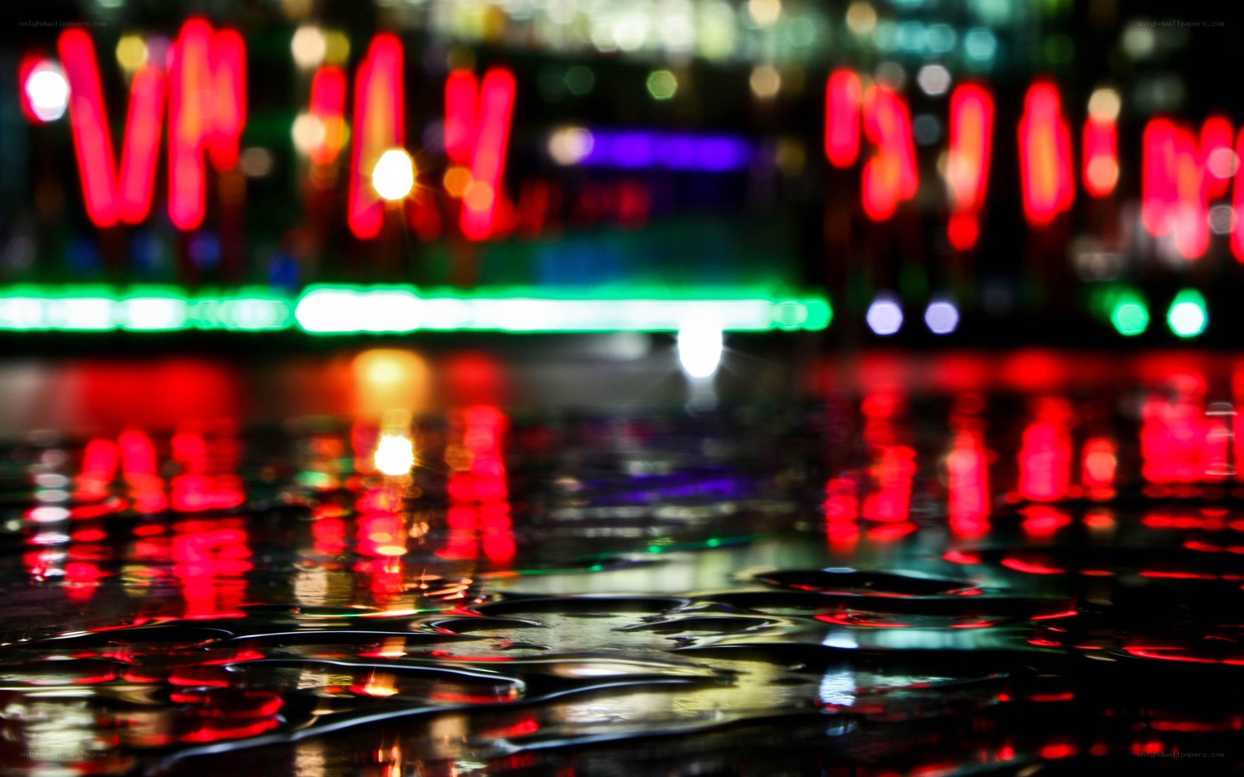 neon lights reflecting on wet pavement
