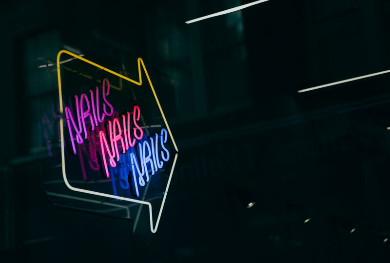 Neon nails sign in dark room