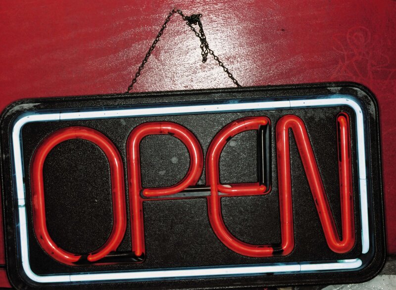 Neon open sign on red wall
