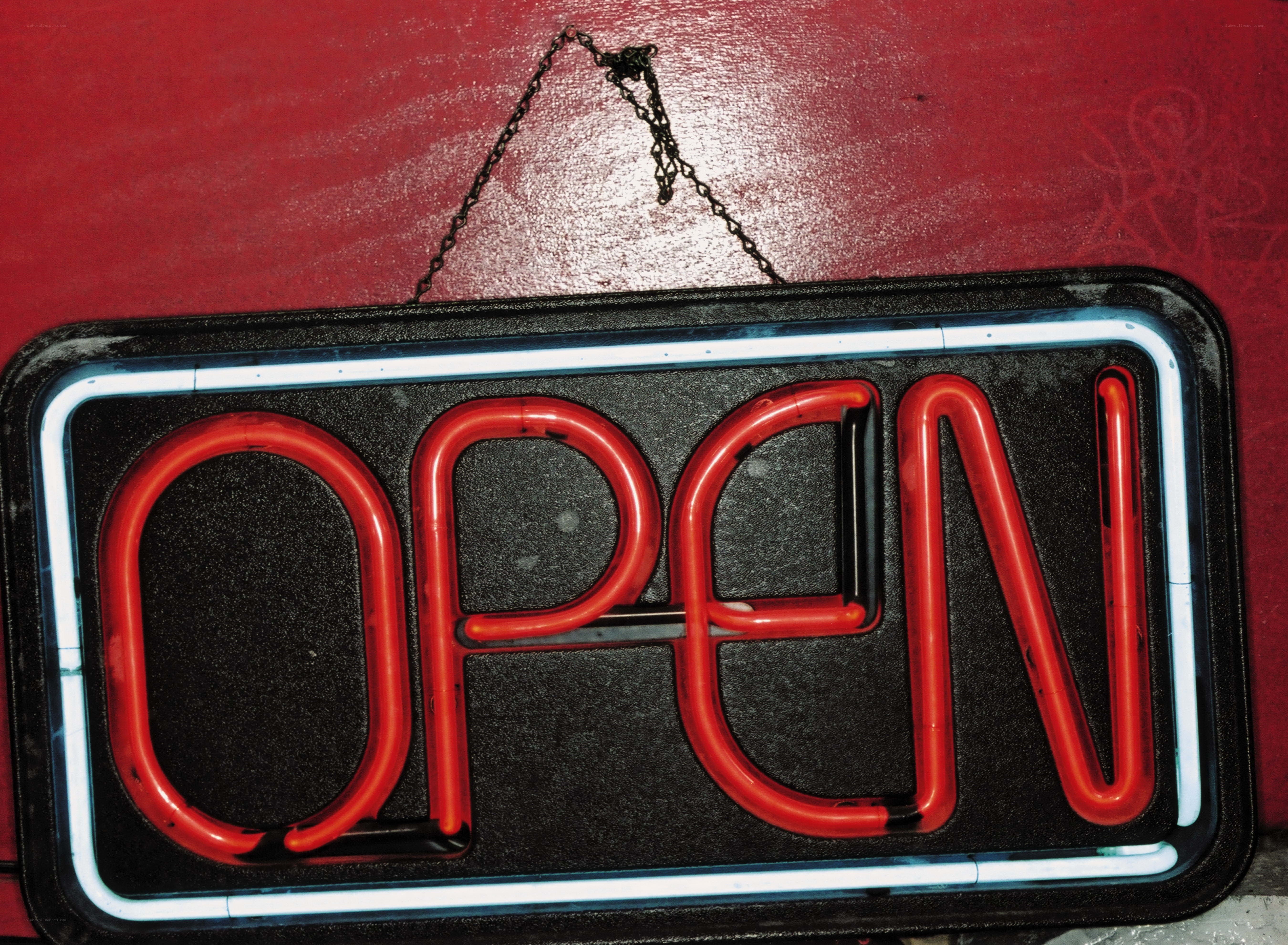 Neon open sign on red wall