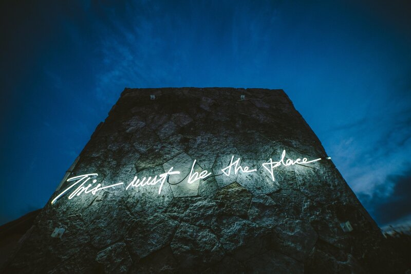 Neon Sign on Stone Wall