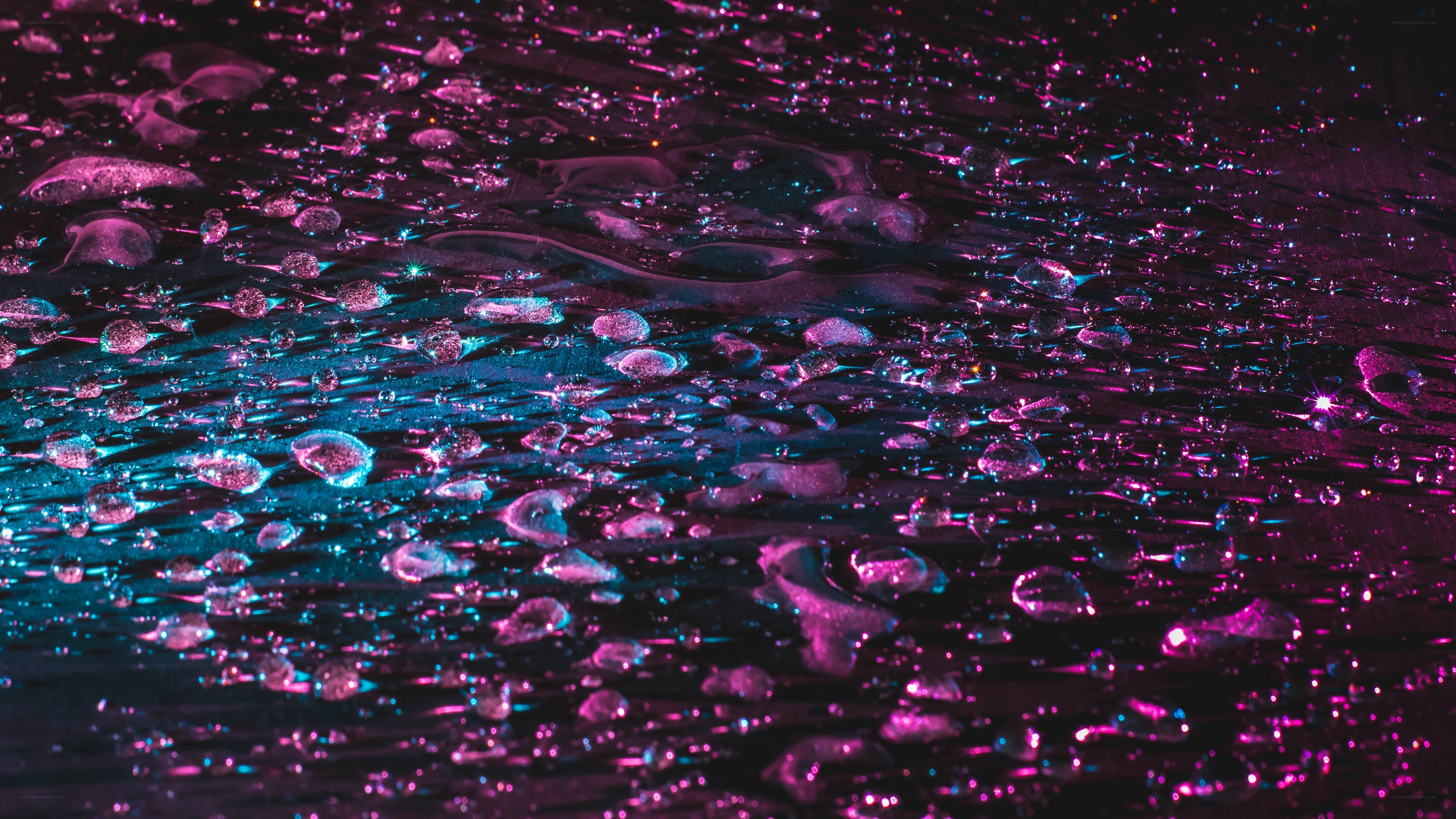 neon water droplets on dark surface