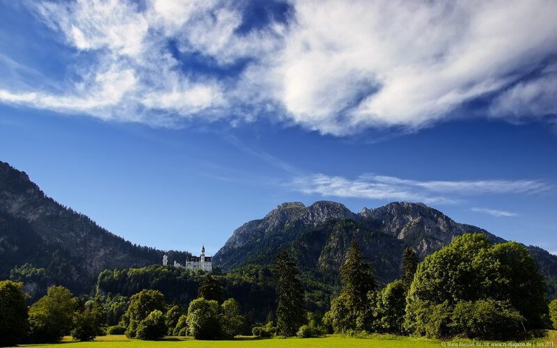 Neuschwanstein Castle — Blue, Serene, Afternoon, Photograph, Mountains, Trees, Sky, Green