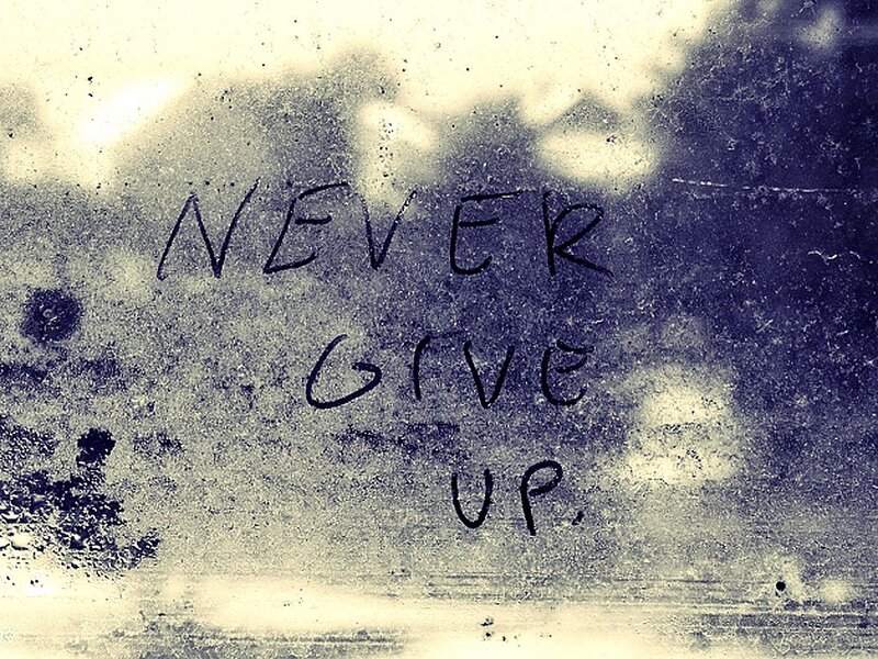 Never give up written on glass